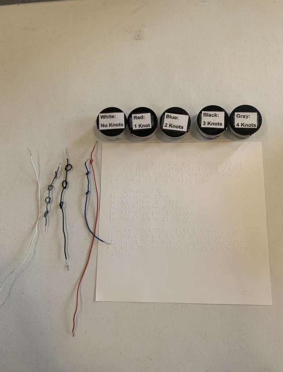 Four electrical wires knotted to make distinctions between the 4 with braille instructions next to them