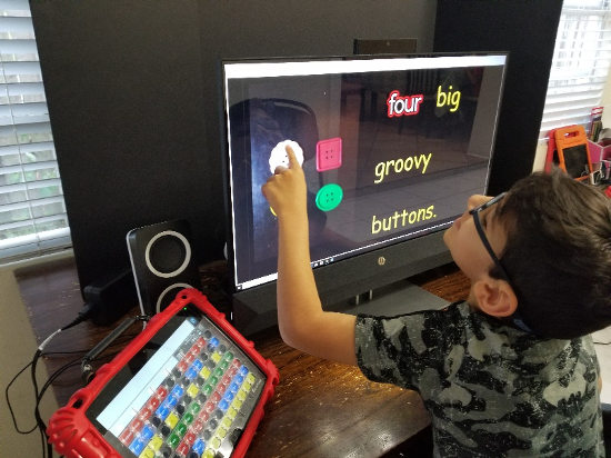 A boy points to buttons on the screen
