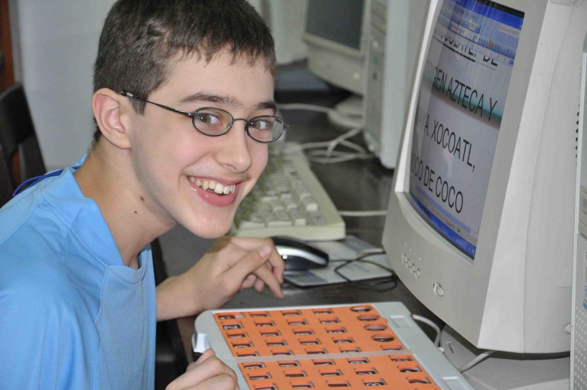 A boy with CVI works at the computer.