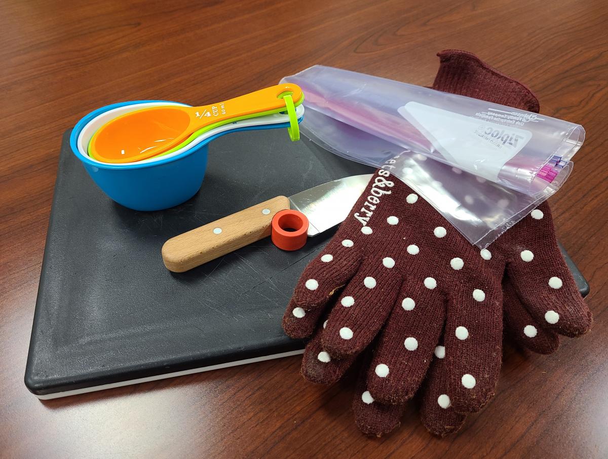 Cooking tools including a cutting board, knife, gloves, and measuring cups