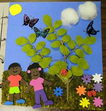 Project with twigs and leaves and drawn on butterflies around it and cotton balls as clouds and two paper dolls attached