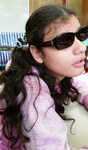 Heba, a young woman, wearing sun glasses and sitting in a chair