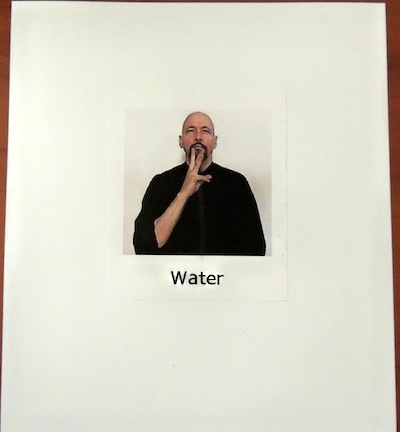 Index card with a picture of a man signing "water"
