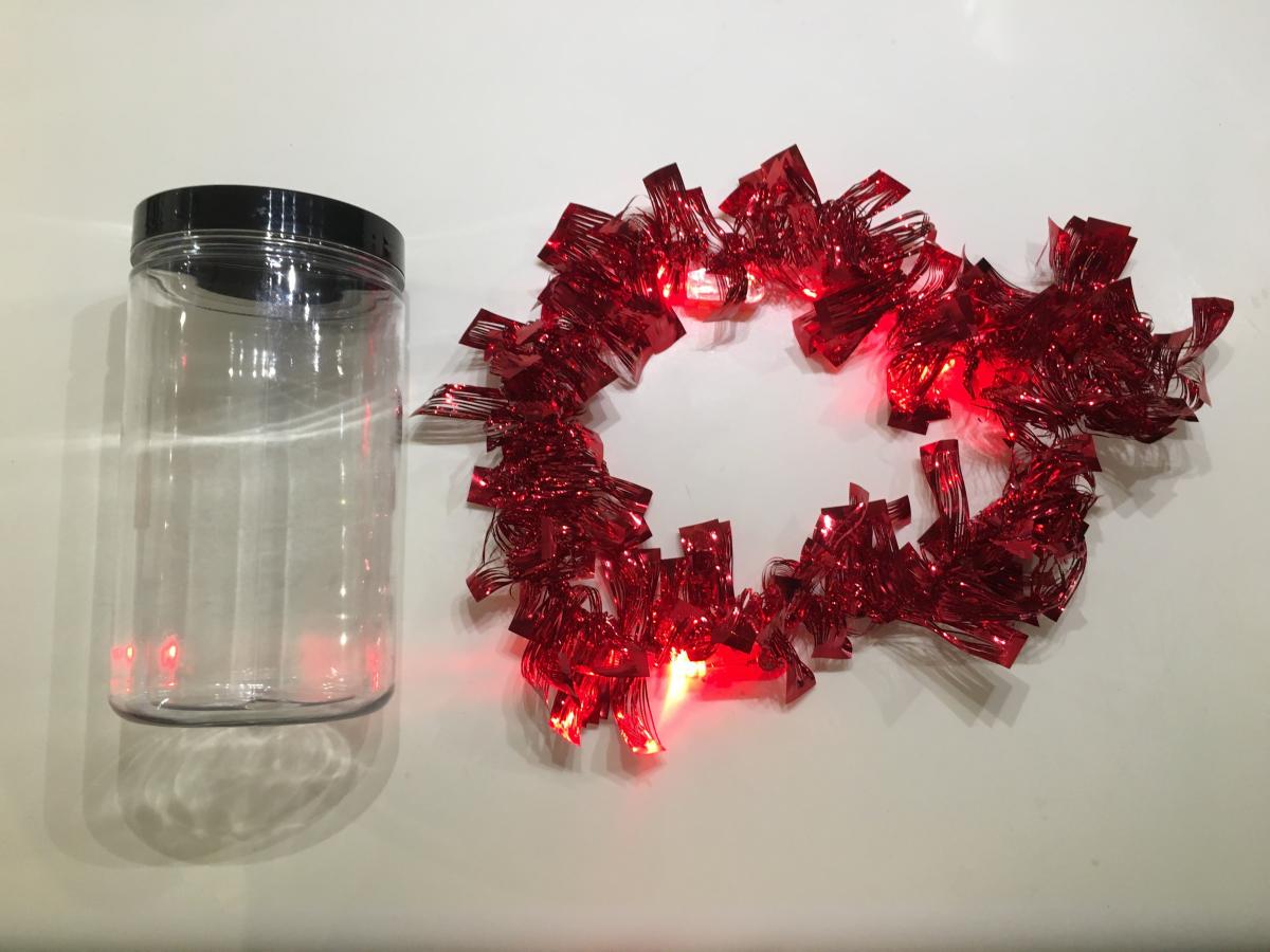 Empty jar and red mylar garland with 3 finger lights