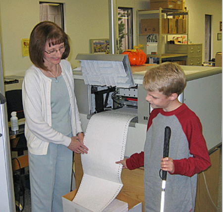 Seedlings creator Debra Bonde with a student by the braille production machine 