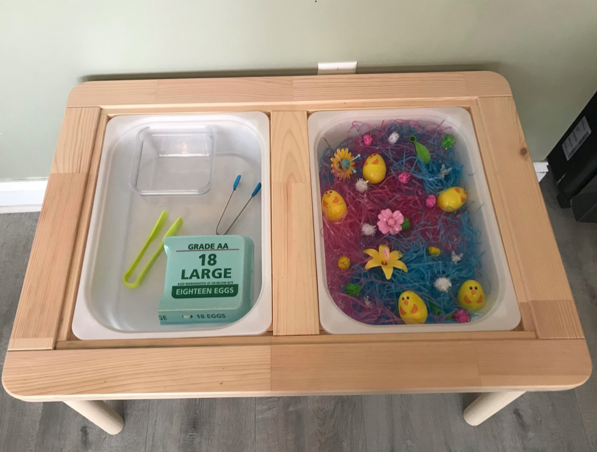Spring sensory bin with plastic eggs and flowers