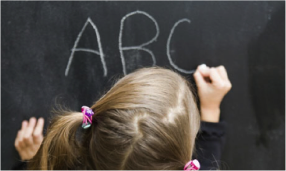 child writing "ABC" on chalkboard