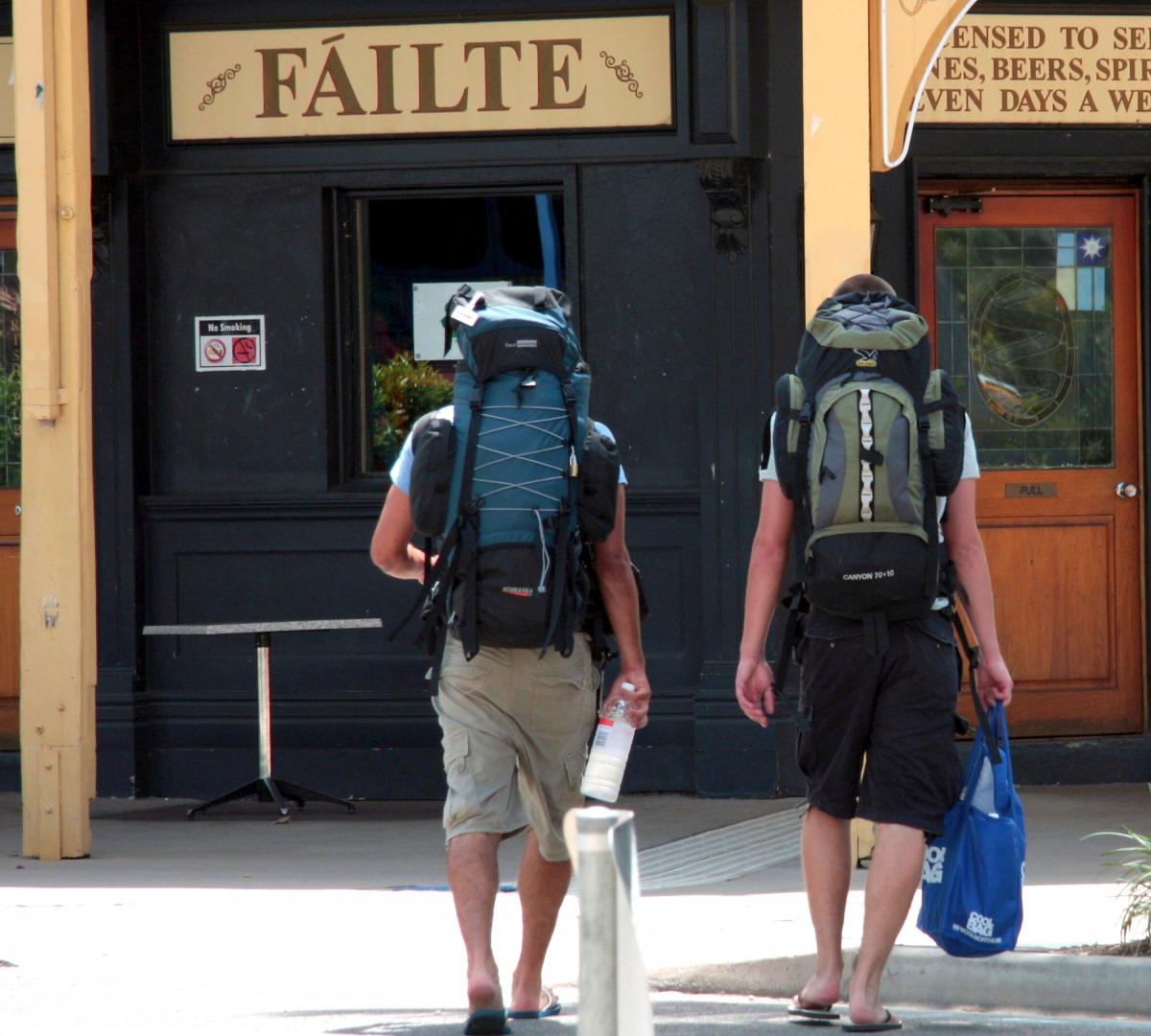 two people walking with camping backpacks