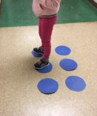 Student standing on dots 1 and 2 to make braille letter "b"