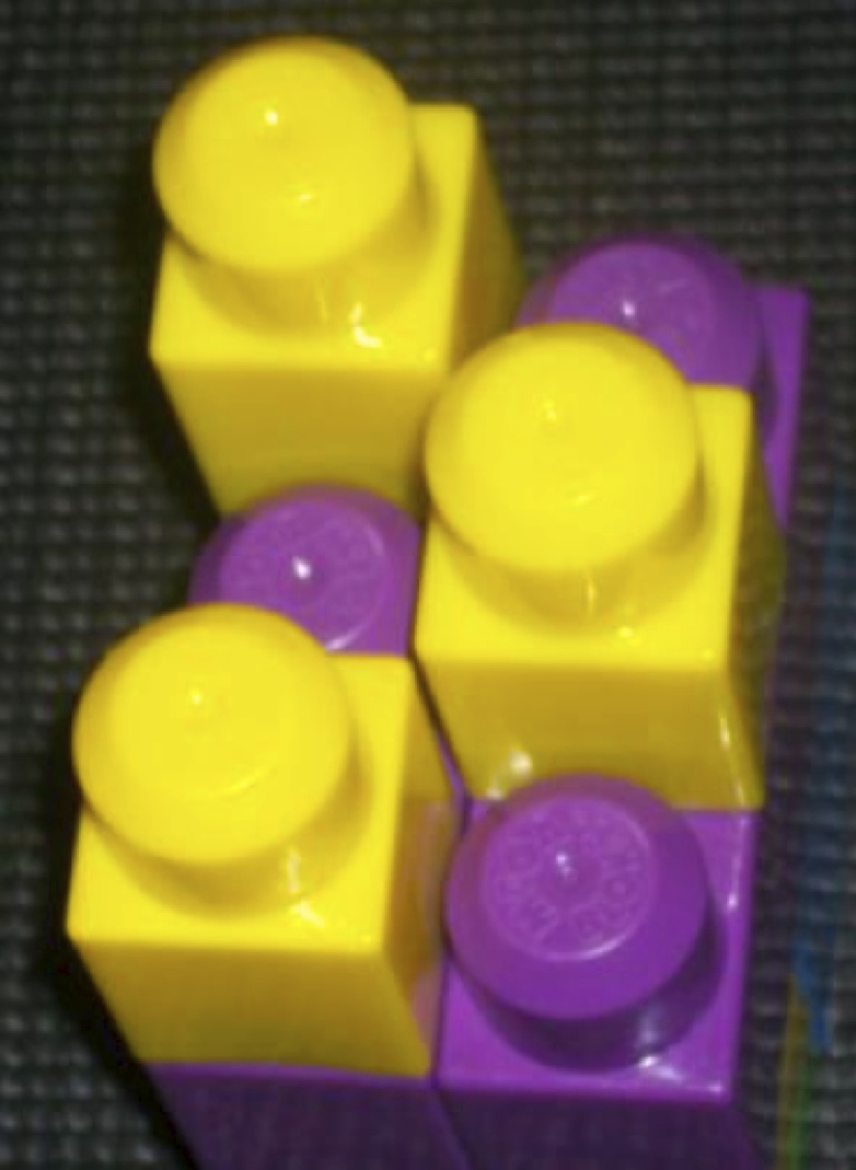 Braille cell made from Mega Bloks with letter “o” displayed.