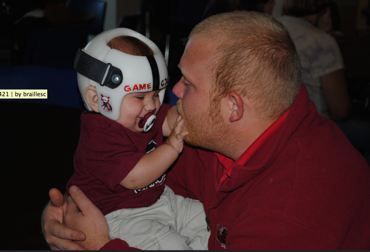 A baby explores Dad's beard.