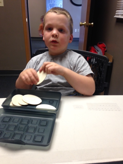 Boy reading braille on desk schedule