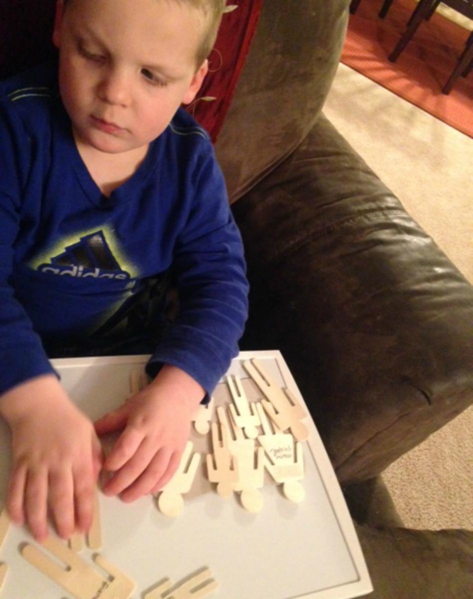 A boy examines wooden figures