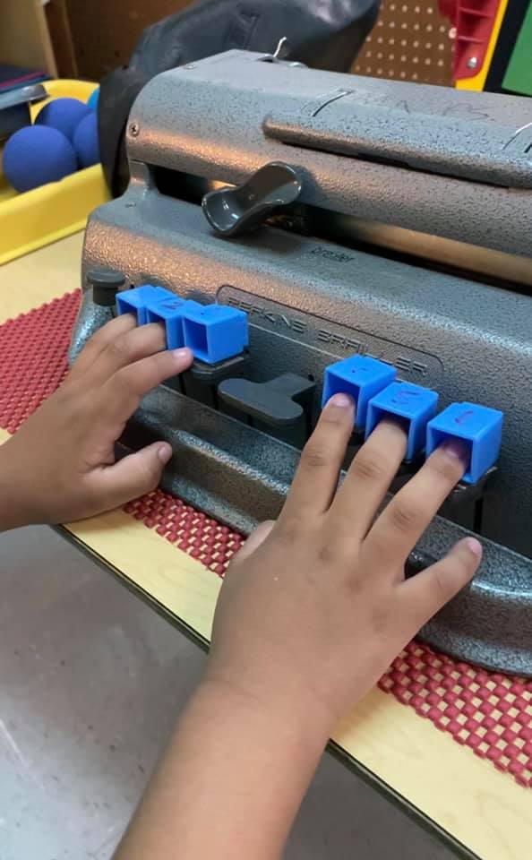Blue Unifix cubes attached to keys of braillewriter