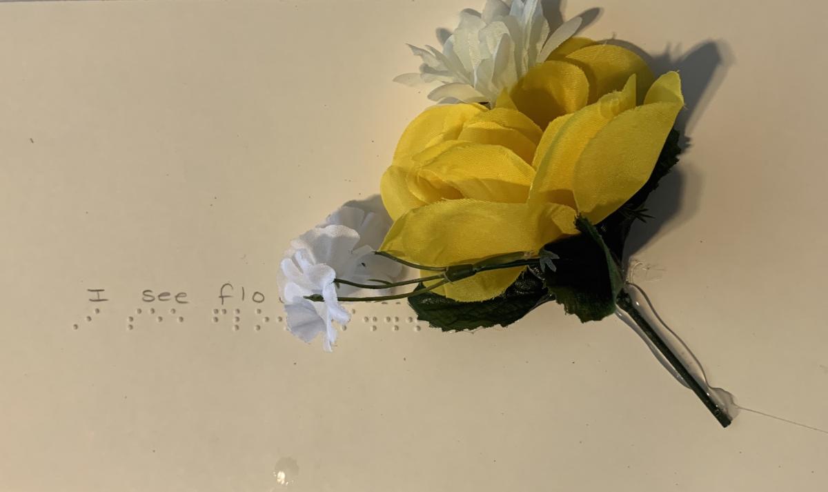 Artificial flowers with braille text "I see flowers."