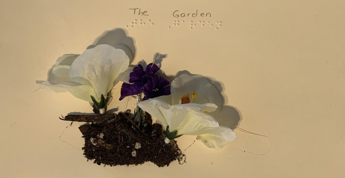 Title page of "The Garden" book with flowers and dirt.