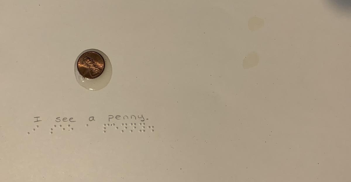Penny with braille text "I see a penny."