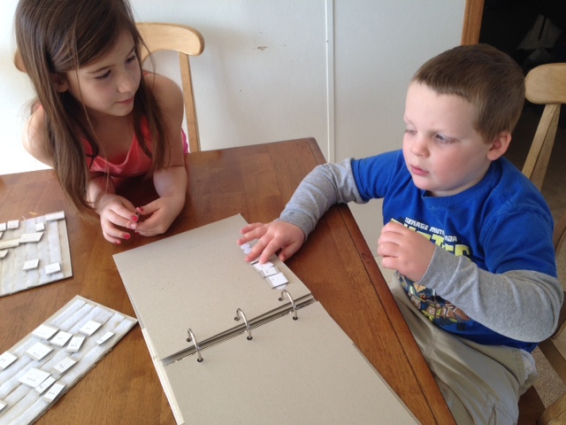 Two children make braille sentences
