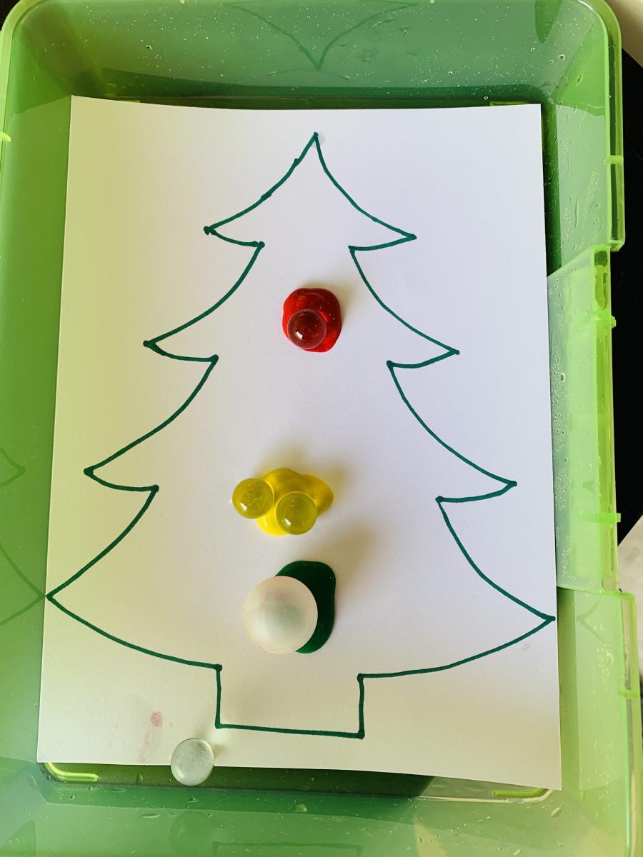 Different colored squirts of paint under each marble on the Christmas tree