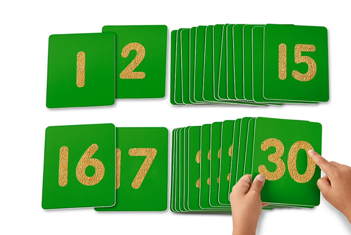 Number flashcards with child hands exploring 