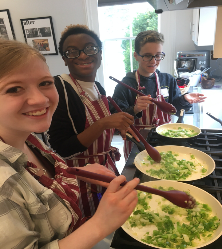 Students stirring vegetables on the stovetop