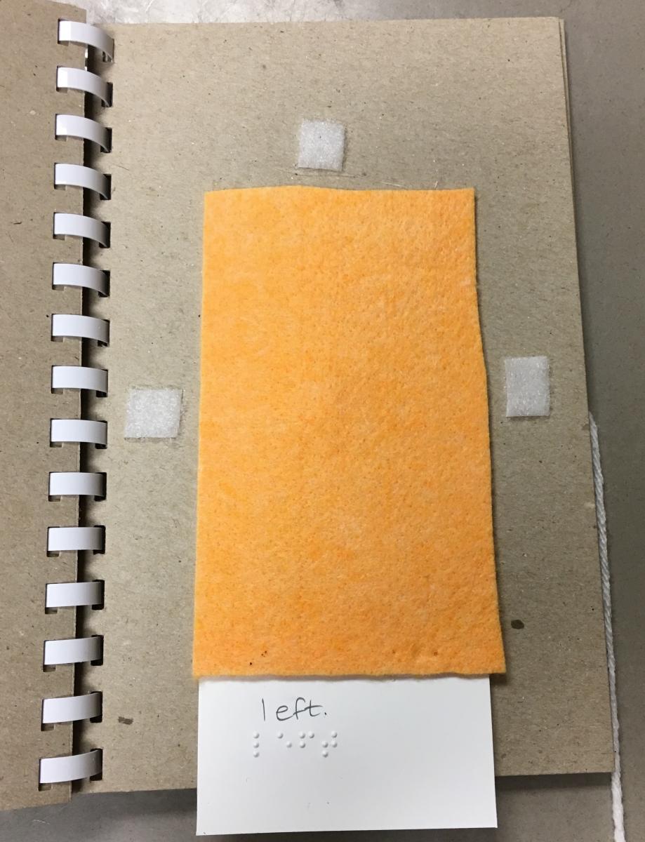Cloth flap covering page with "left" on braille/print word card at bottom of page