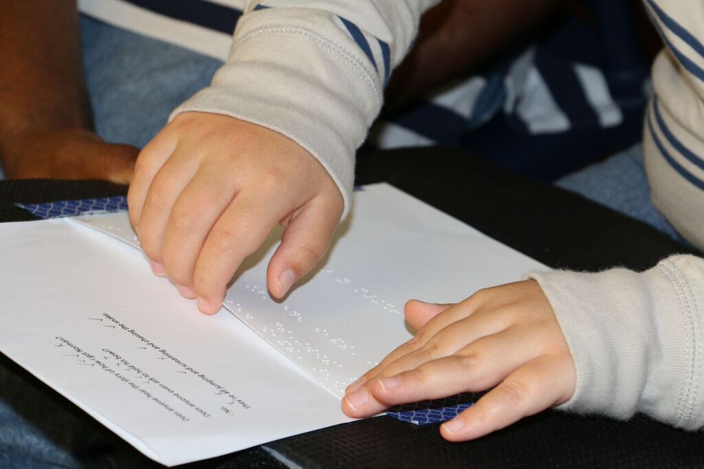 A child reading a page of braille