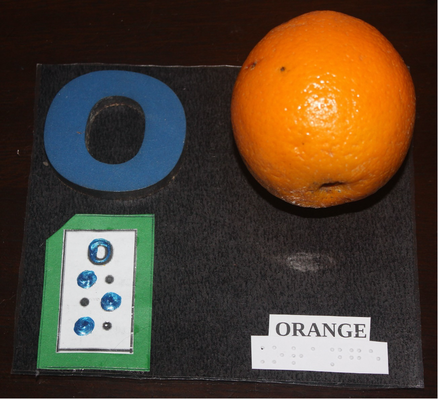 Letter "O" written in print and with corresponding braille and an orange