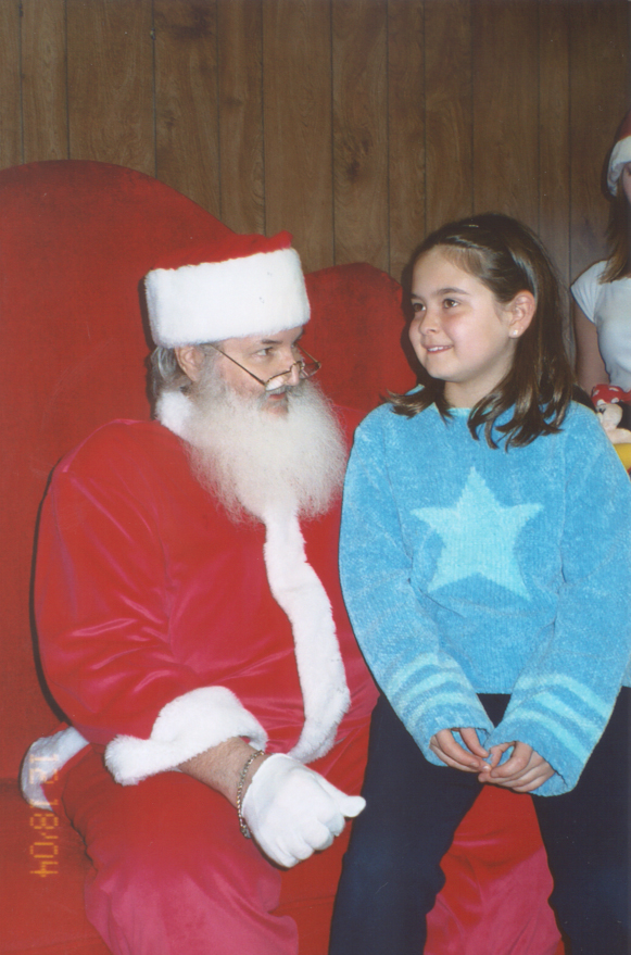 A girl sits on Santa's lap