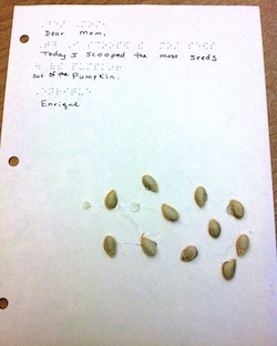 Page with braille and handwriting "Dear mom, today I scooped the most seeds out of the pumpkin. Eugine"