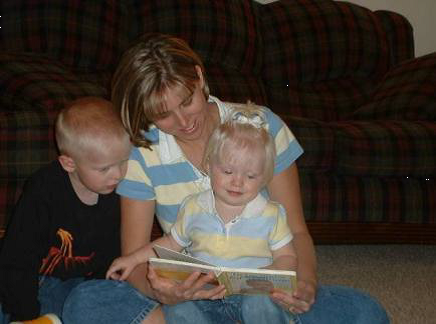 A mother reads with two young children