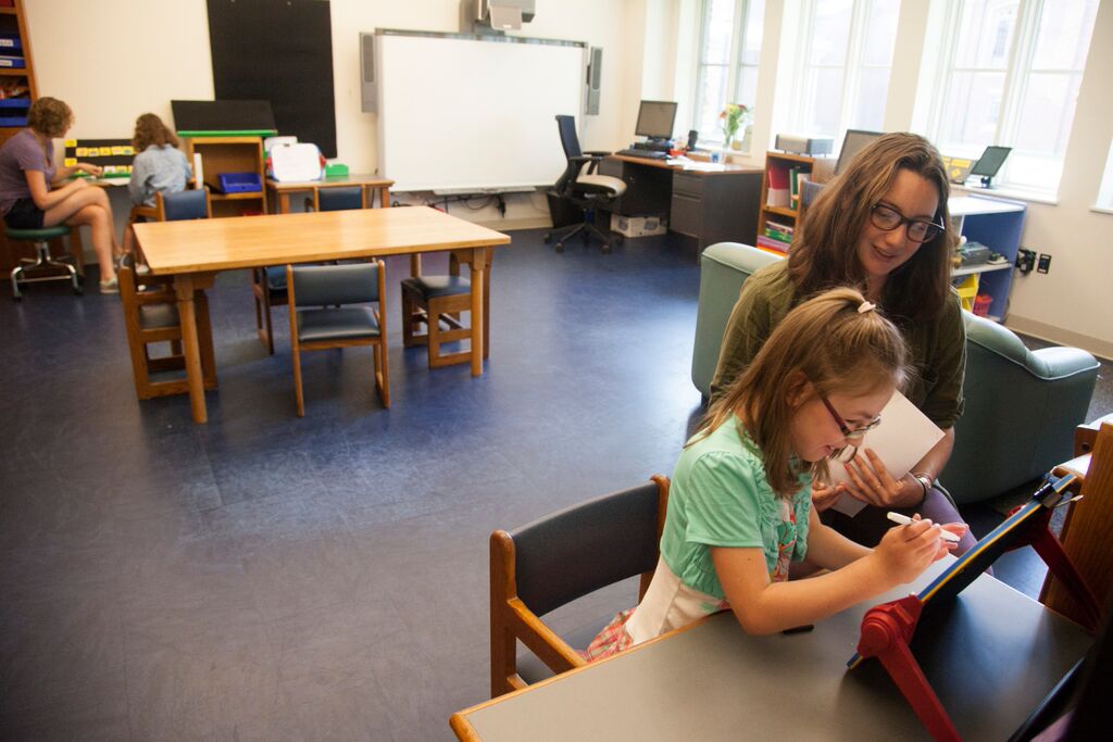 student with teacher using slant board