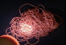 Flashlight shining on red beads