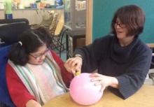 Student with teacher and pink balloon