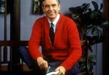 Mr. Rogers wearing a red cardigan