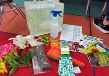 “Story Box for Spring” including books and objects such as gloves, rakes, water bottles, picture cards for pages of the book