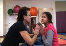 A girl and her teacher doing the prayer position