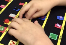Boy's hands on textured symbols on Velcro board