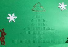 Green holiday card with braille Christmas tree and tactile stickers