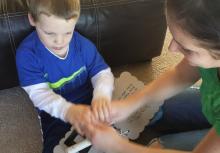 A young boy who is deafblind signs with his mother