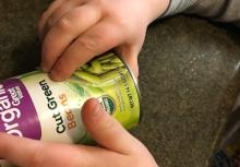 Reading braille labels on can of green beans