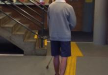 A photograph shows a teenage boy in school uniform using his cane and walking along a tactile pathway towards the Attendance Office. 