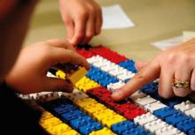 Adult pointing to Tack-Tiles while student manipulated them.