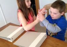 Two children using tactile sign language