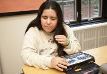 a female student using a braille notetaker
