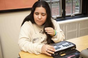 Girl using braille notetaker