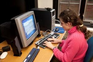 Teenage girl with fingers on computer keyboard