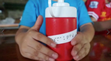 Hands holding a thermos with braille on it