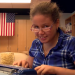 Girl with glasses using braillewriter