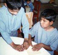 Two classmates read braille postcards